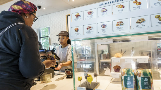 美国佐治亚州亚特兰大市，一名顾客在星巴克门店使用手机应用支付。